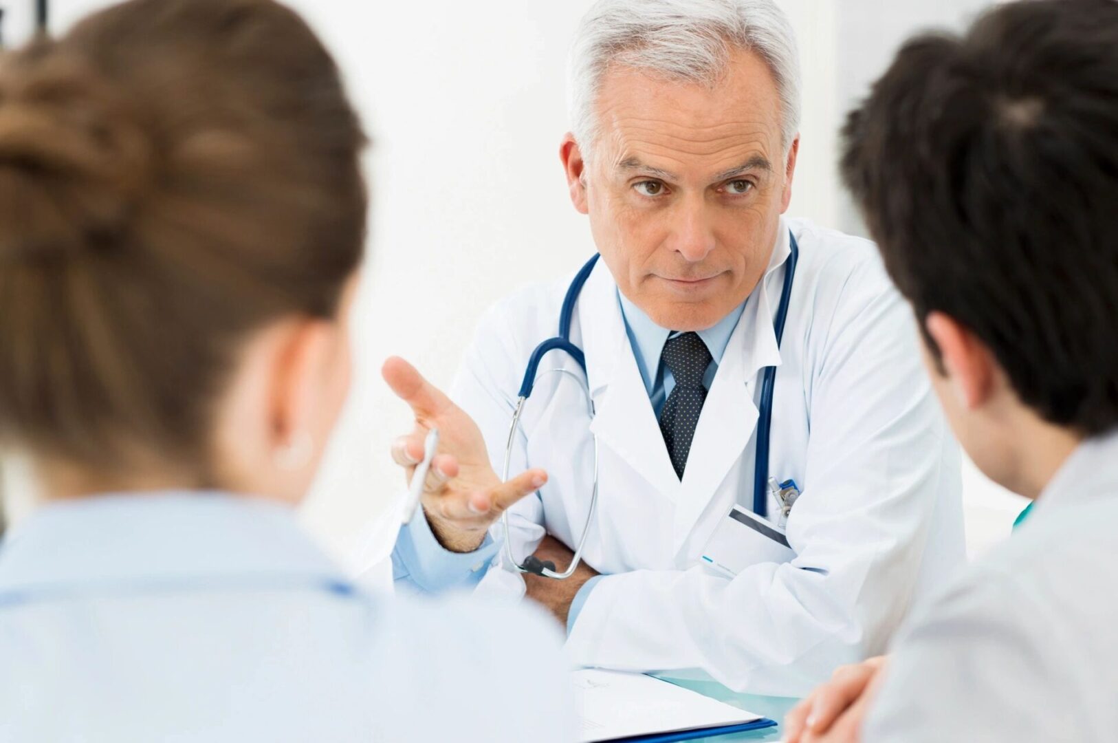 A doctor is talking to two other doctors.