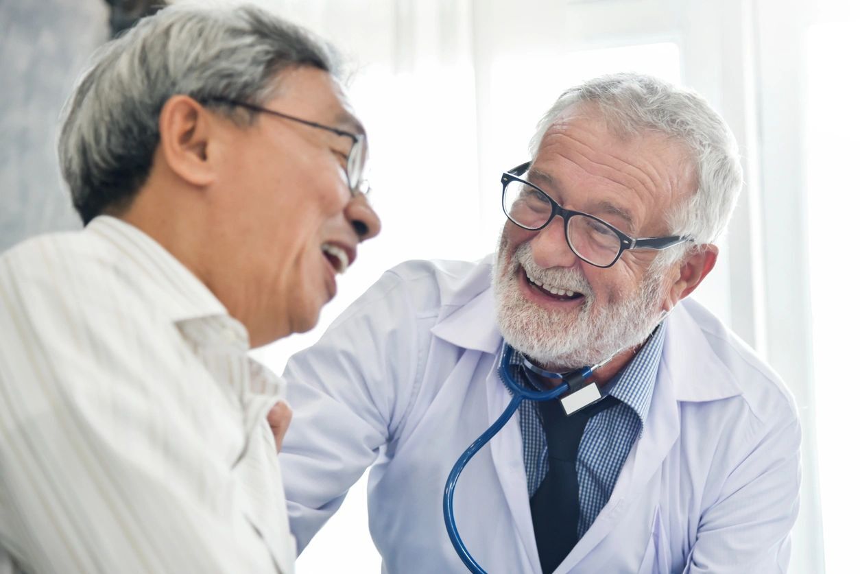 A man in white shirt and tie holding a stethoscope.