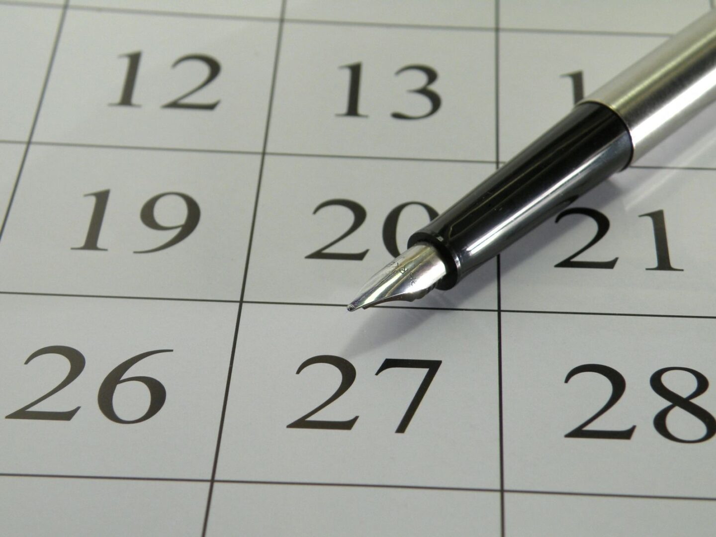 A close up of a pen on the calendar